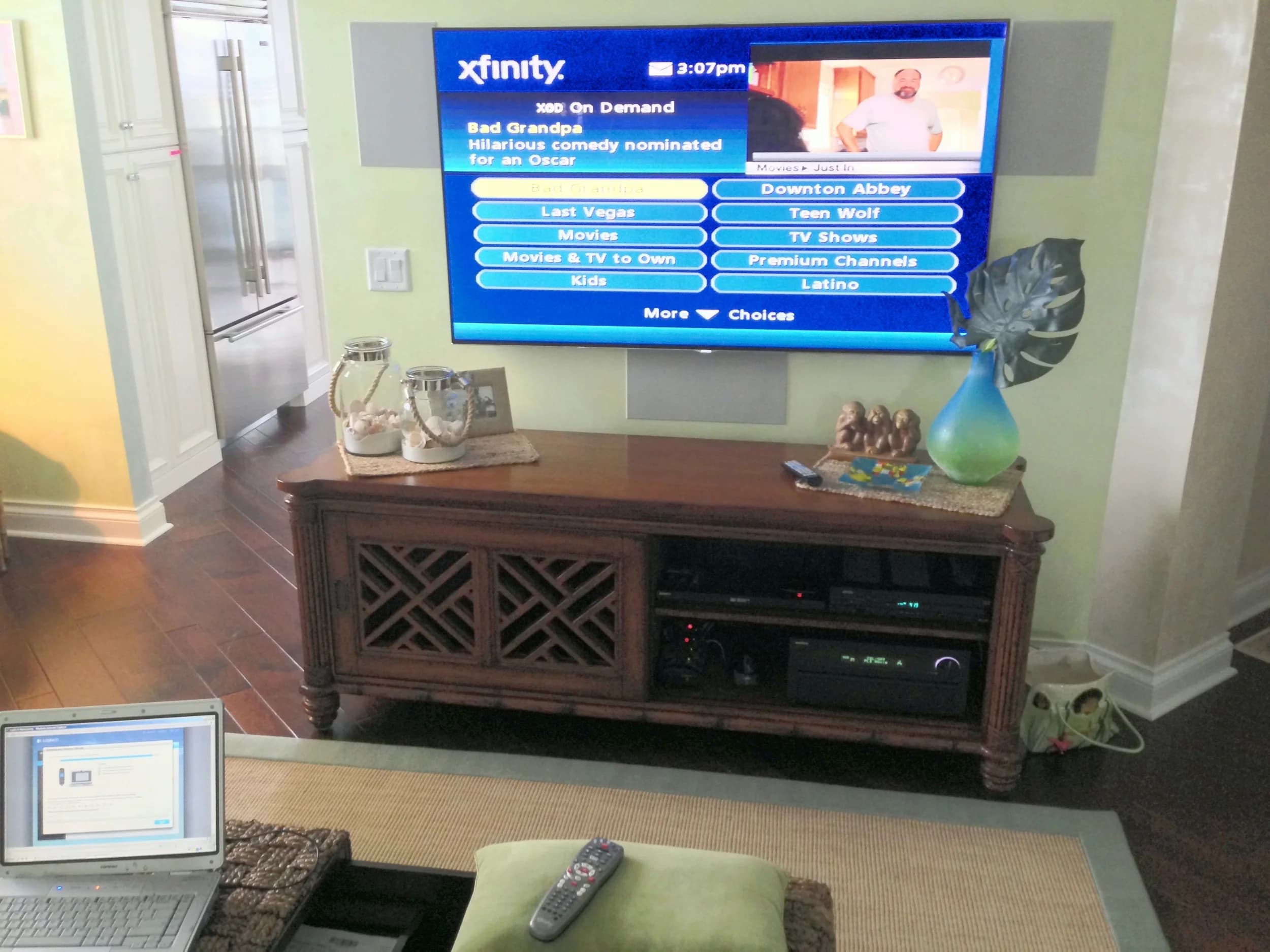 Wall-mounted display above a wood console with concealed cabling