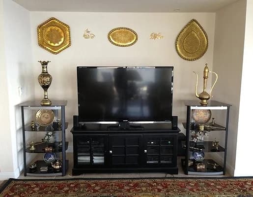 Flat-panel display on a console between display cabinets in a formal room