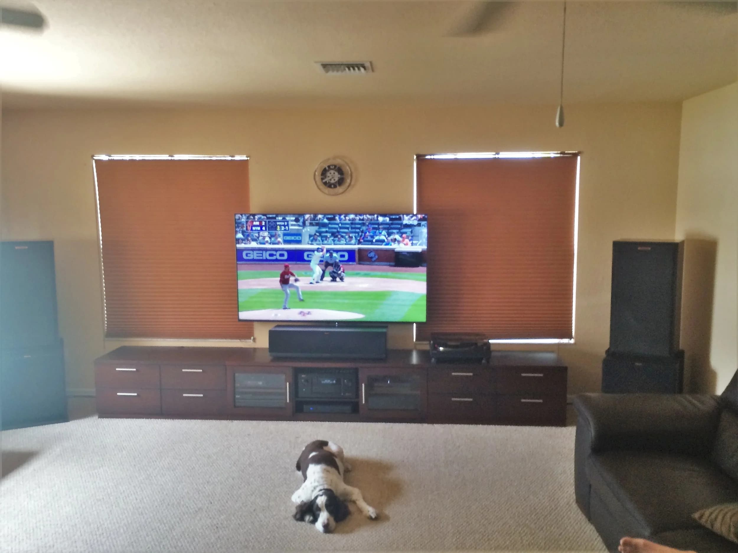 Media room with a wall-mounted display flanked by floor-standing tower speakers