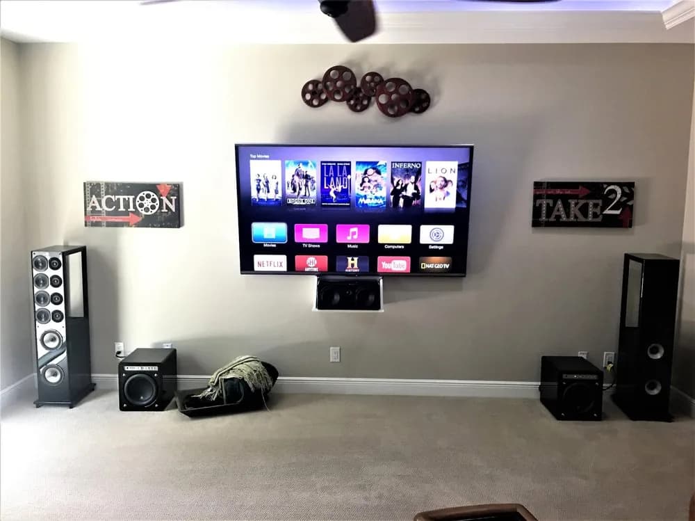 Surround system with a wall-mounted display, centre channel, floor-standing towers, and two subwoofers